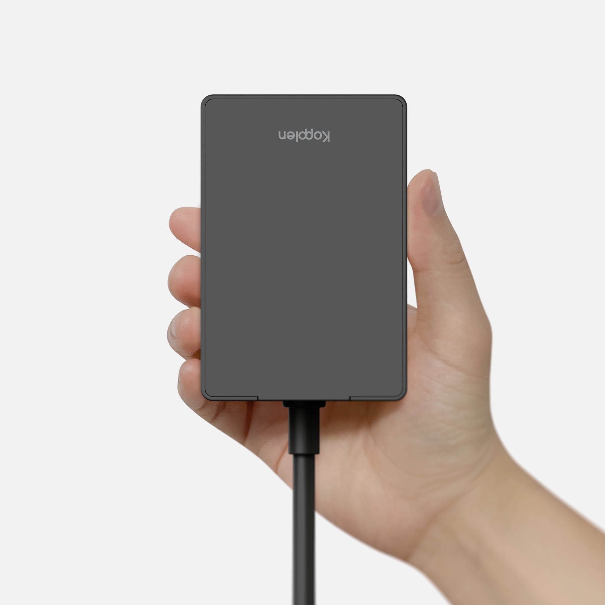Hand holding power brick to show scale and portability