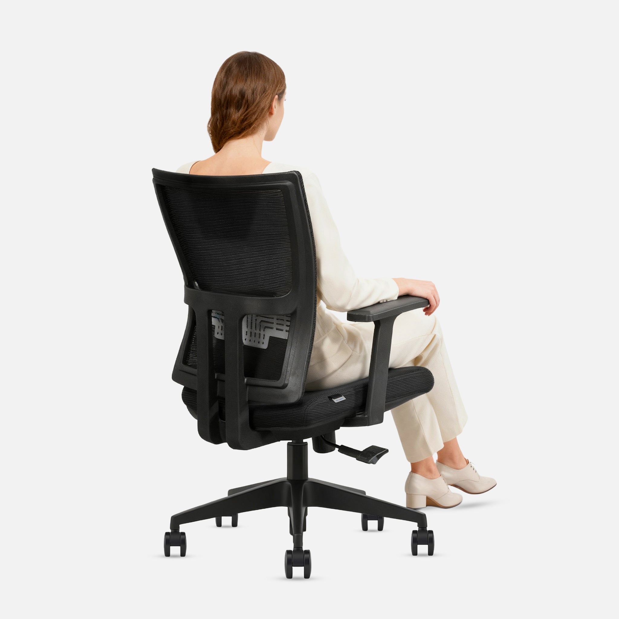 Person sitting on a black office chair with a white background