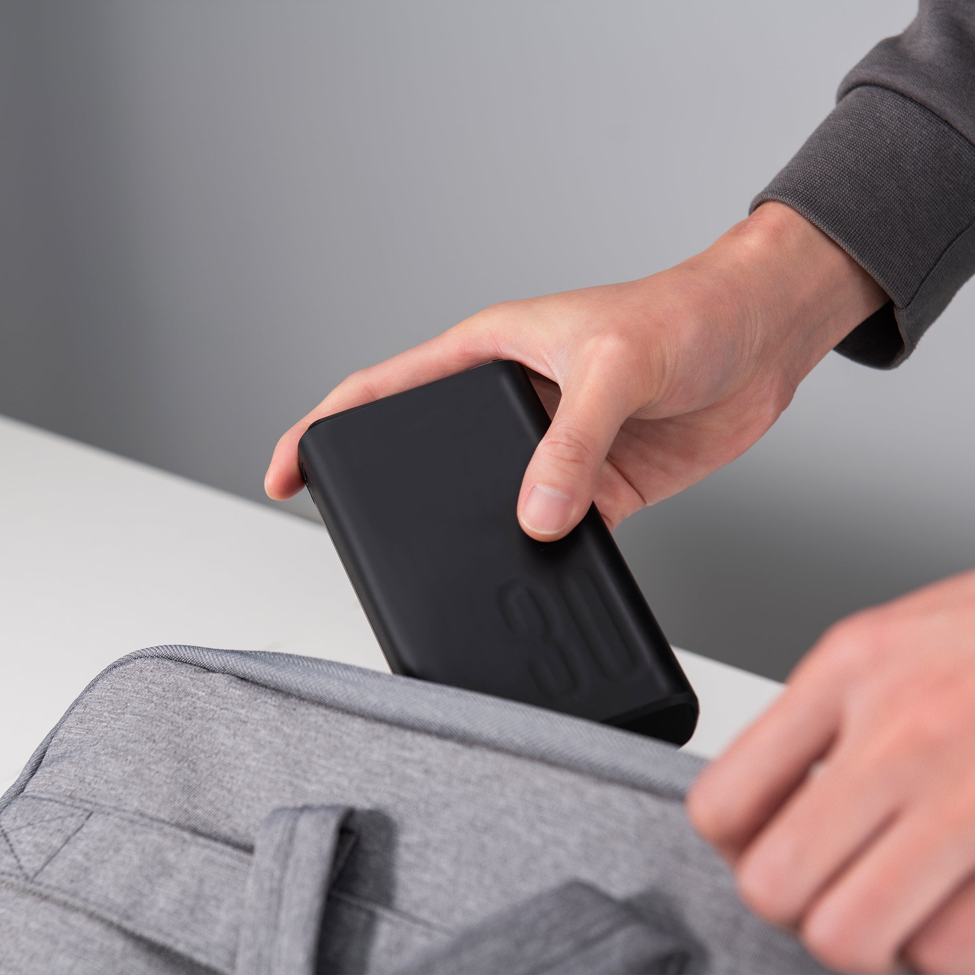 Large power bank being placed into a laptop bag