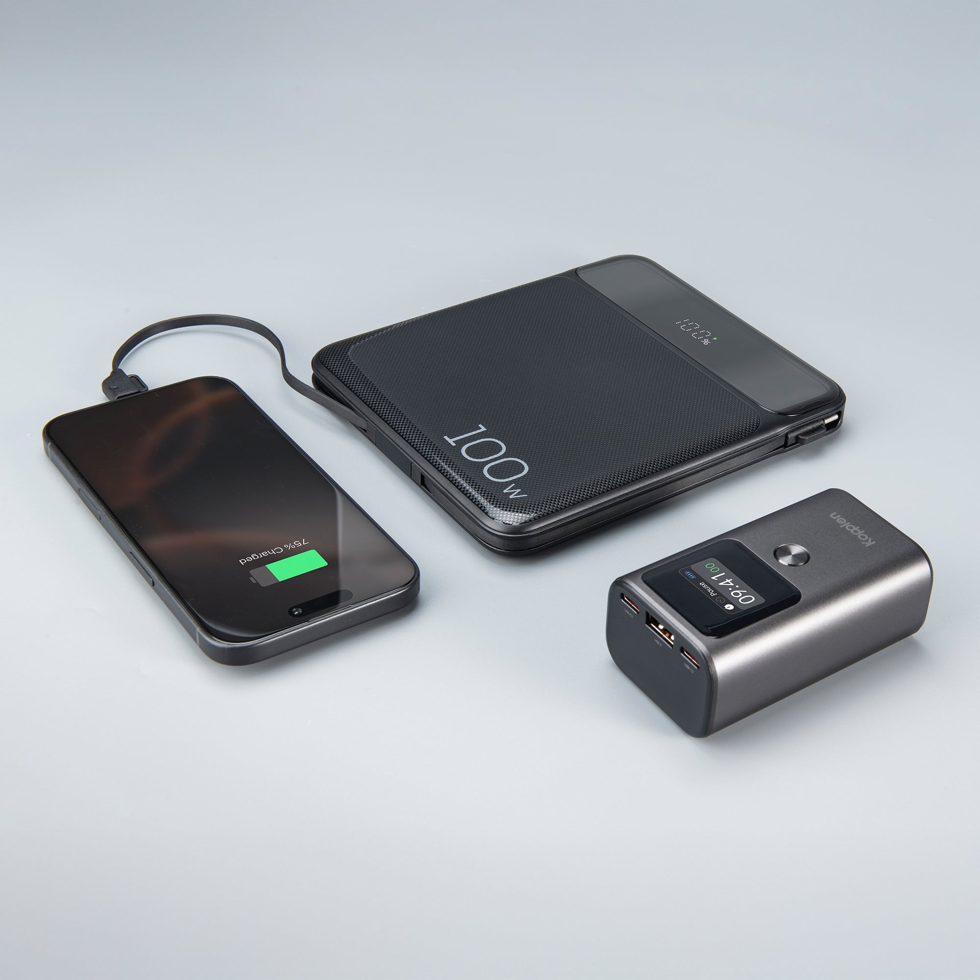 2 power banks laying down, one plugged into iPhone