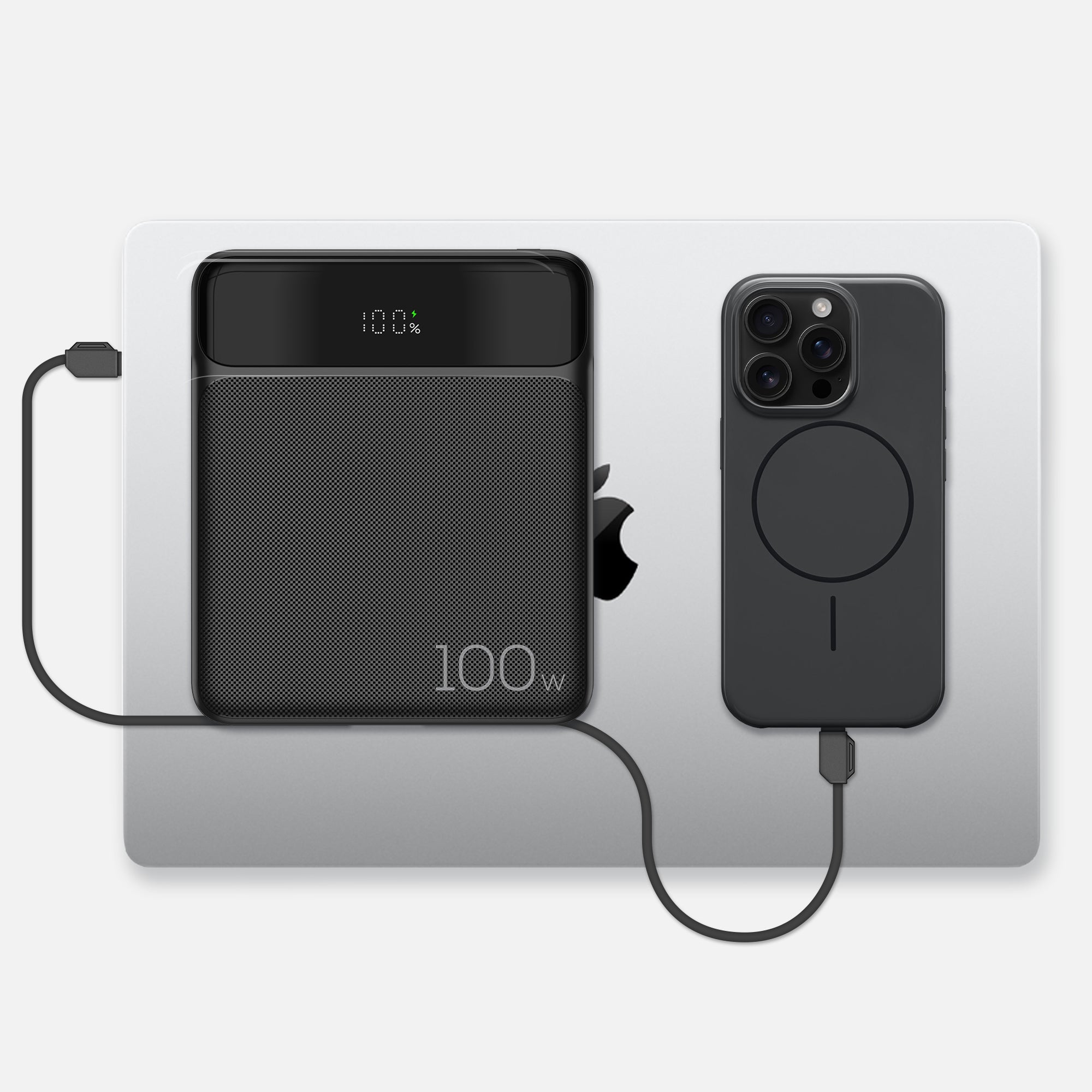 Power bank on top of MacBook Pro, charging both the laptop and an iPhone